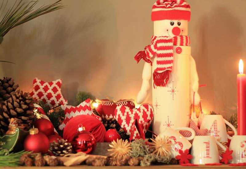 Weihnachtsdeko-Ideen-mokowo-schneemann und adventskerze mit weihnachtskugeln und stoffherzen